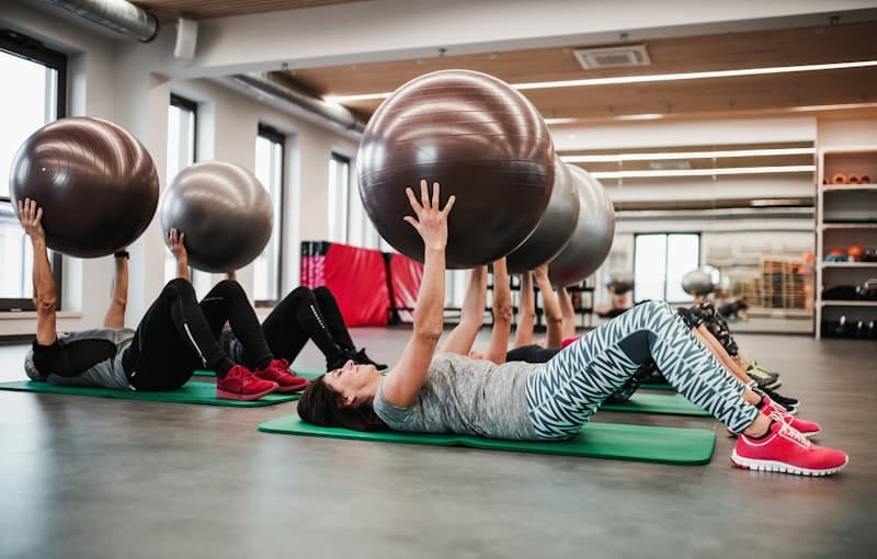 Groep senioren die oefeningen doen met fitballen