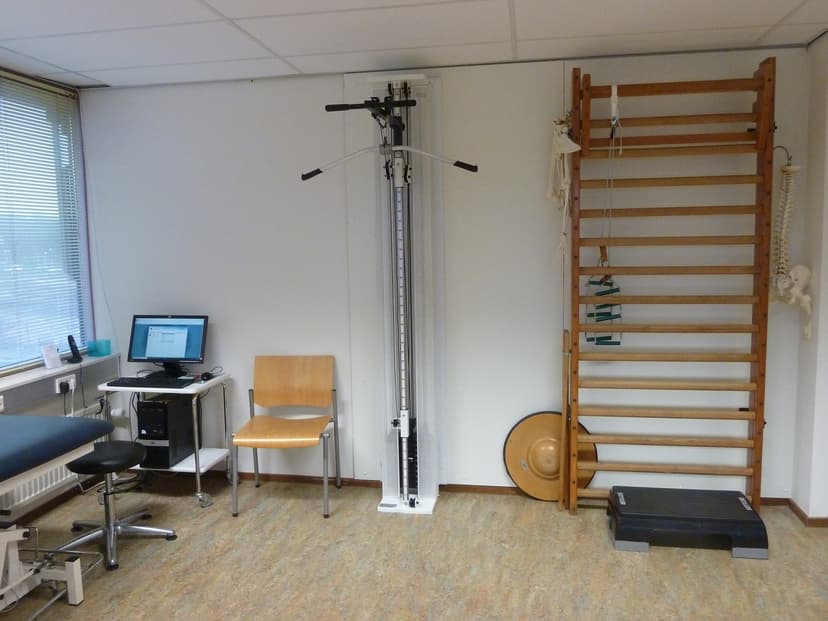 De oefenruimte met wandrekken en kabelmachine